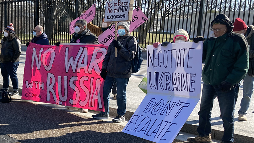 A protester holding a placard saying U.S. war machine: real threat to  peace at a rally against war with Russia sponsored by multiple groups  including CODEPINK: Women for Peace, Black Alliance for